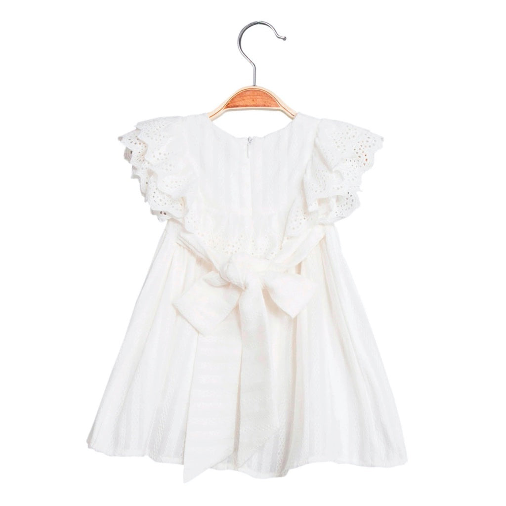 Bebé niña en vestido blanco en toda su longitud sobre una manta